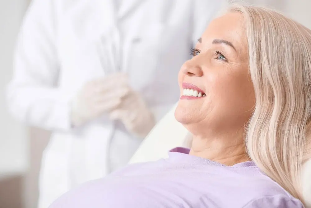A smiling woman after dental implant treatment